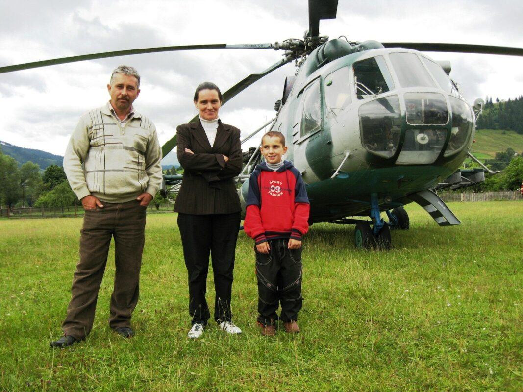 a family standing in front of a helicopter
